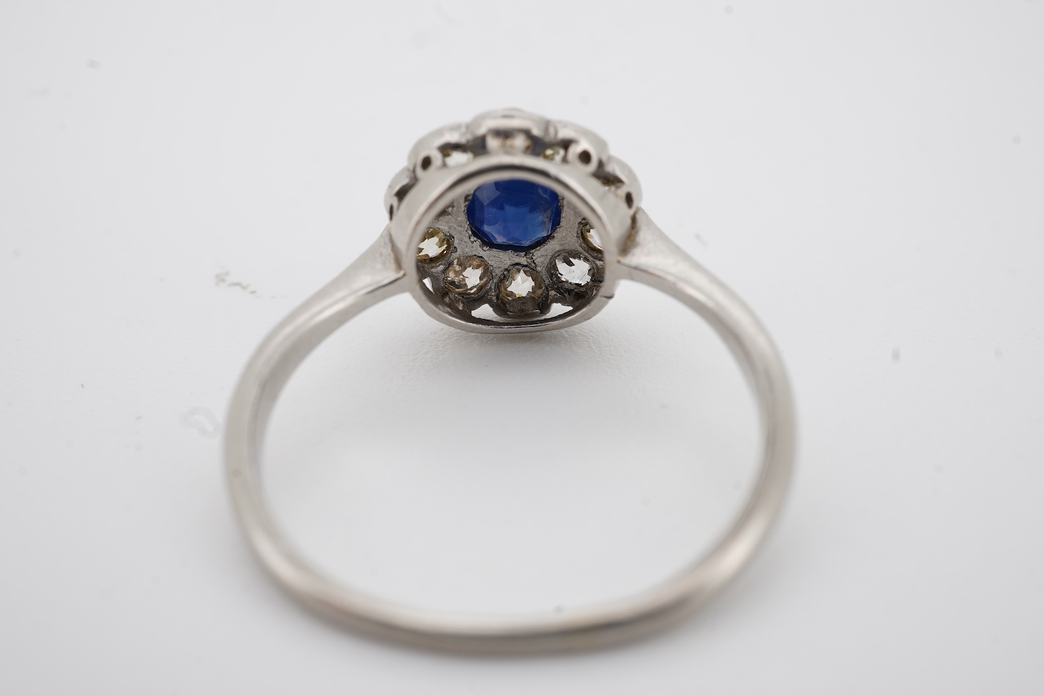 A 1920's white metal(stamped plat), sapphire and diamond set circular flower head cluster ring, size J, gross weight 2.7 grams.